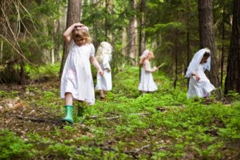 dzieci w białych ubraniach w lesie