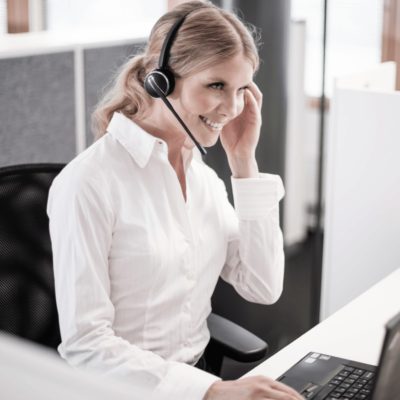 lady sat at office desk wearing headset