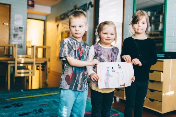 In the picture are children from the Linnainmaa daycare centre, Mio Saarinen, Ellen Äppelqvist and Olivia Hyle, standing on a mat they helped design. The colourful mat is based on a drawing made by the children, who really let their imagination fly!